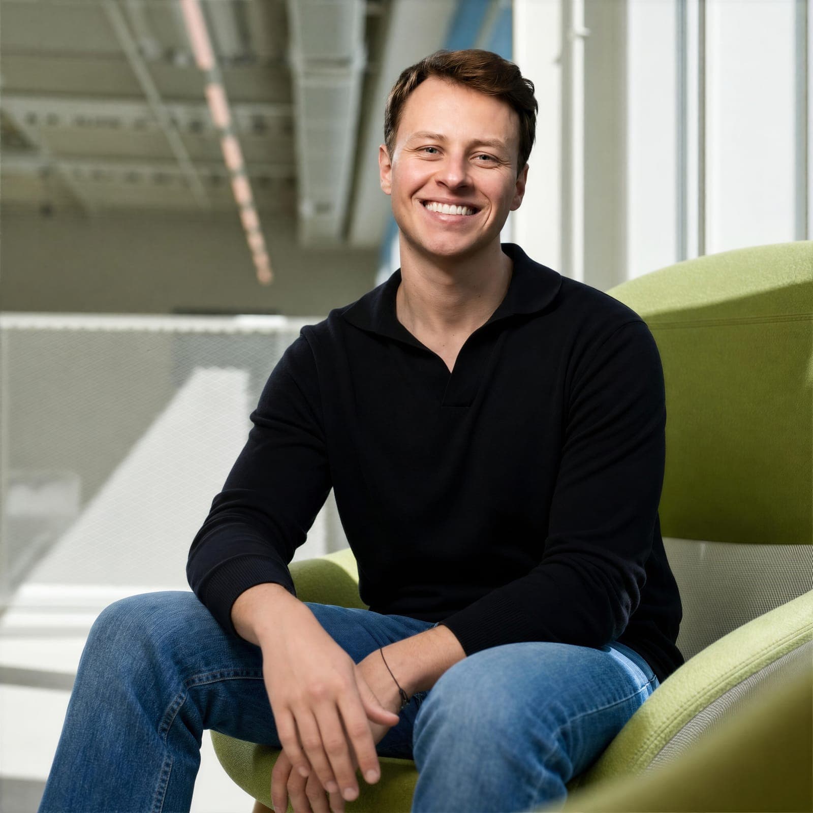 A smiling Nyra Health team member seated in a green chair.