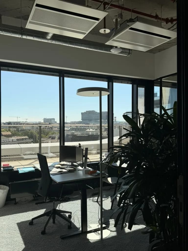 A sunlit desk and terrace view inside Speedinvest's office.