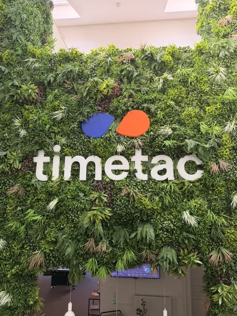 TimeTac's logo mounted on a planted wall inside the company's office.